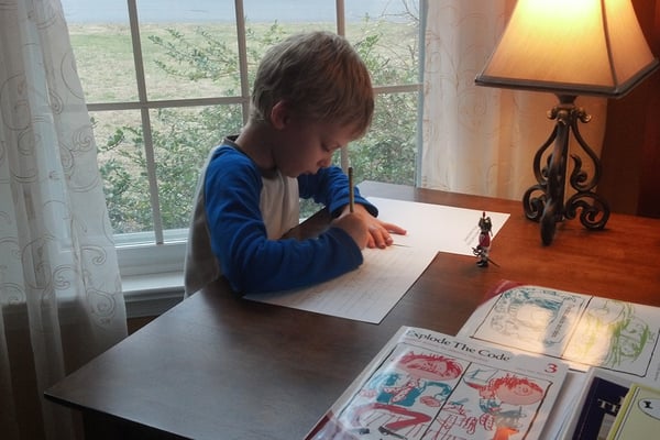 boy practicing handwriting at a table