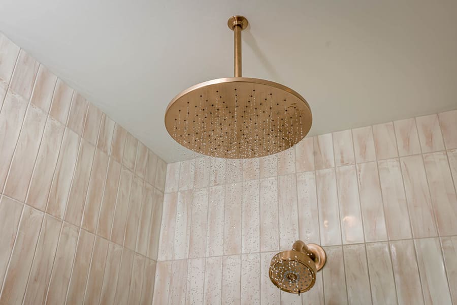 Gold shower head and shower tile in Lancaster Primary Bathroom remodel 