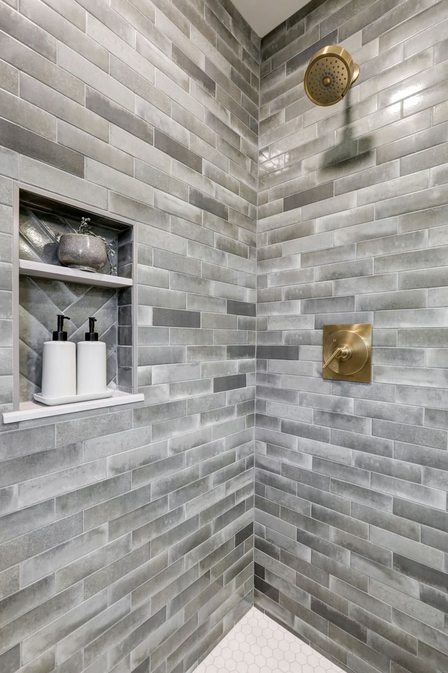tile shower with niche and gold accents in Strasburg primary suite remodel
