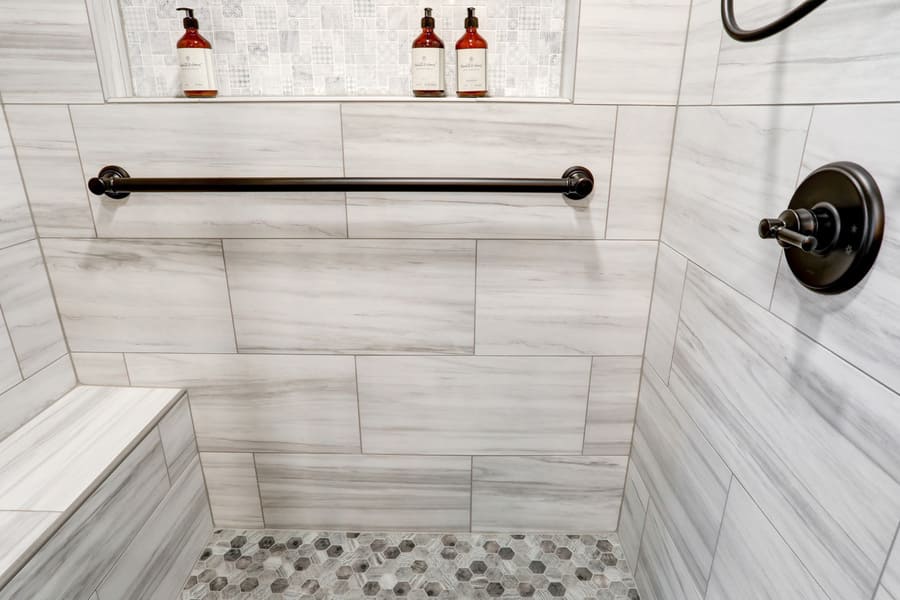 Lancaster Primary Bathroom Remodel with pebble tile shower floor and bench