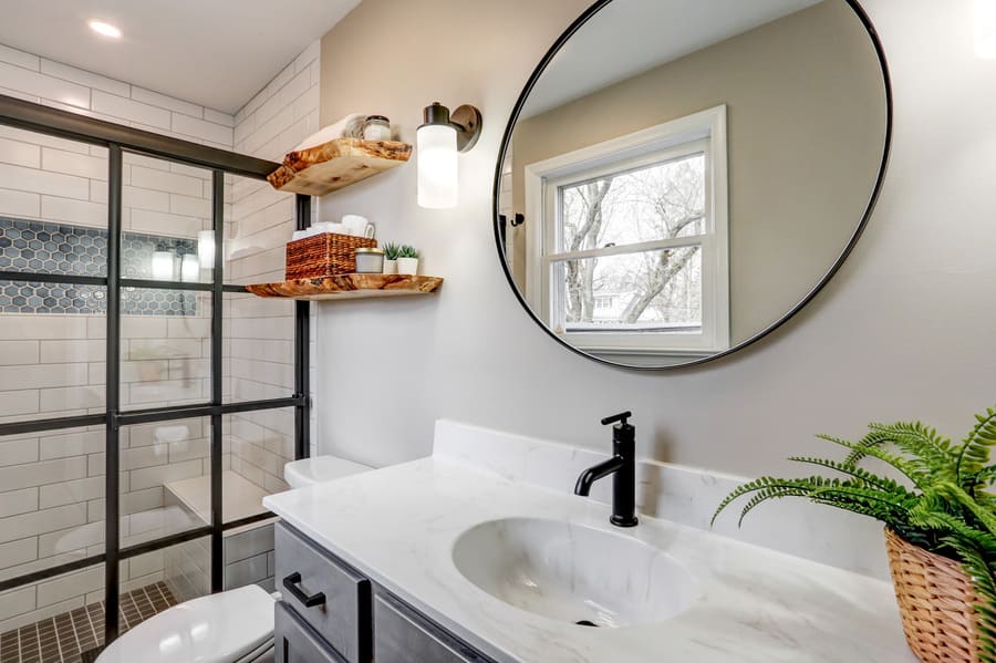 Round mirror and farmhouse door in Lancaster PA bathroom remodel