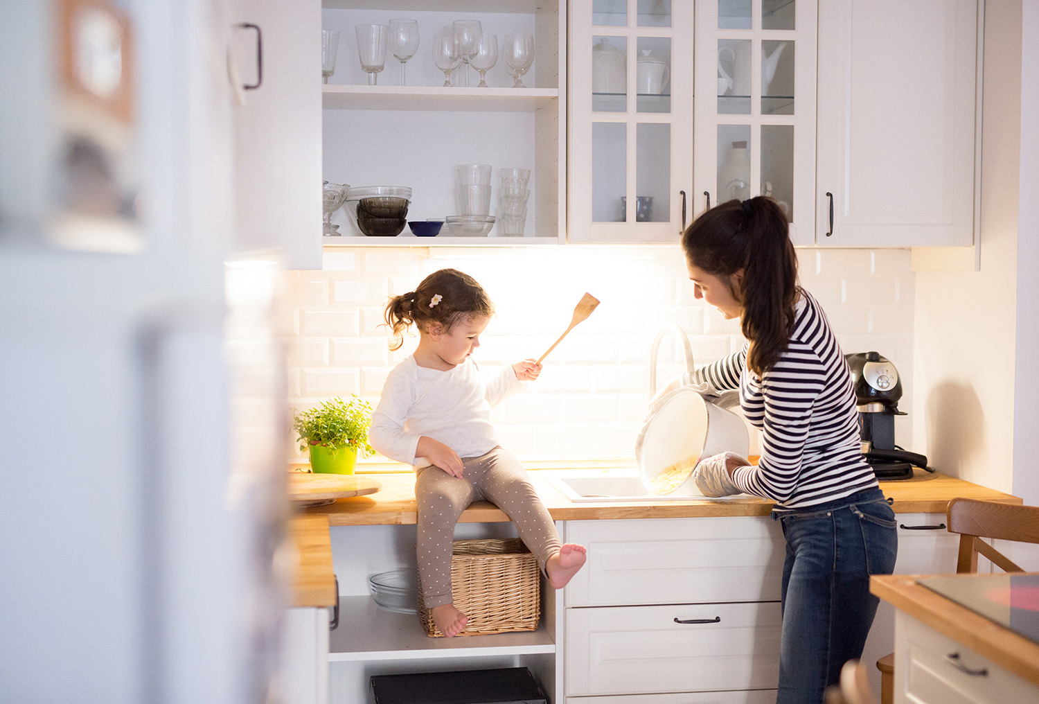 Mother and daughter making pasta in kitchen