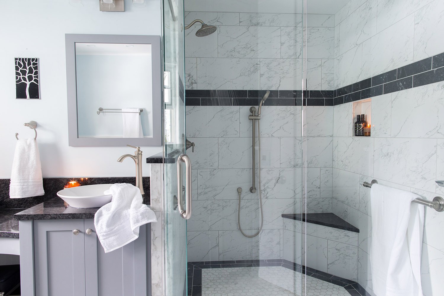 Corner glass enclosed shower with tile walls and bench seat in Millersville Master Bathroom Remodel