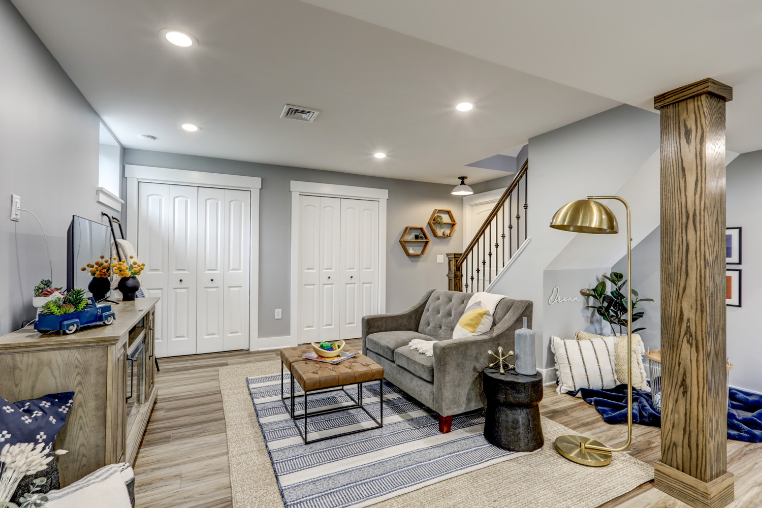 Lititz Basement Remodel with light gray walls and custom newel post