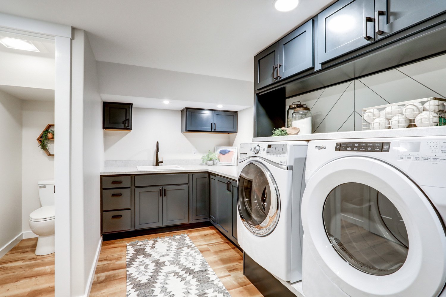 Laundry room with sink and separate toilet room in Lancaster Basement Remodel