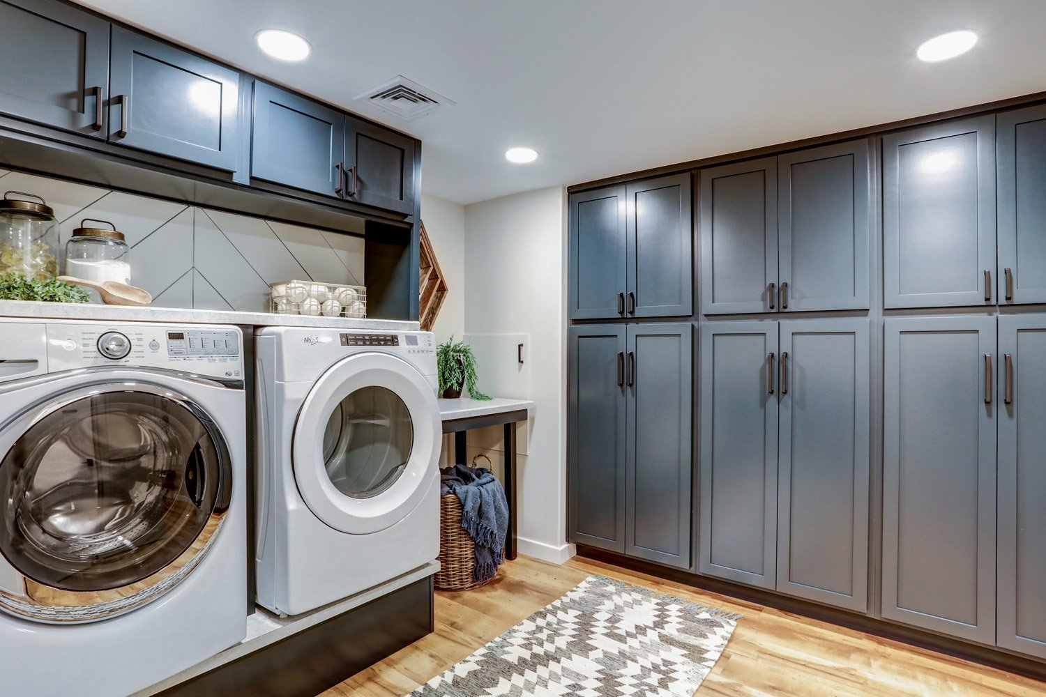 Dark blue cabinets in laundry room in Lancaster Basement Remodel