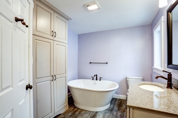 Large primary bathroom with freestanding tub and lavender walls