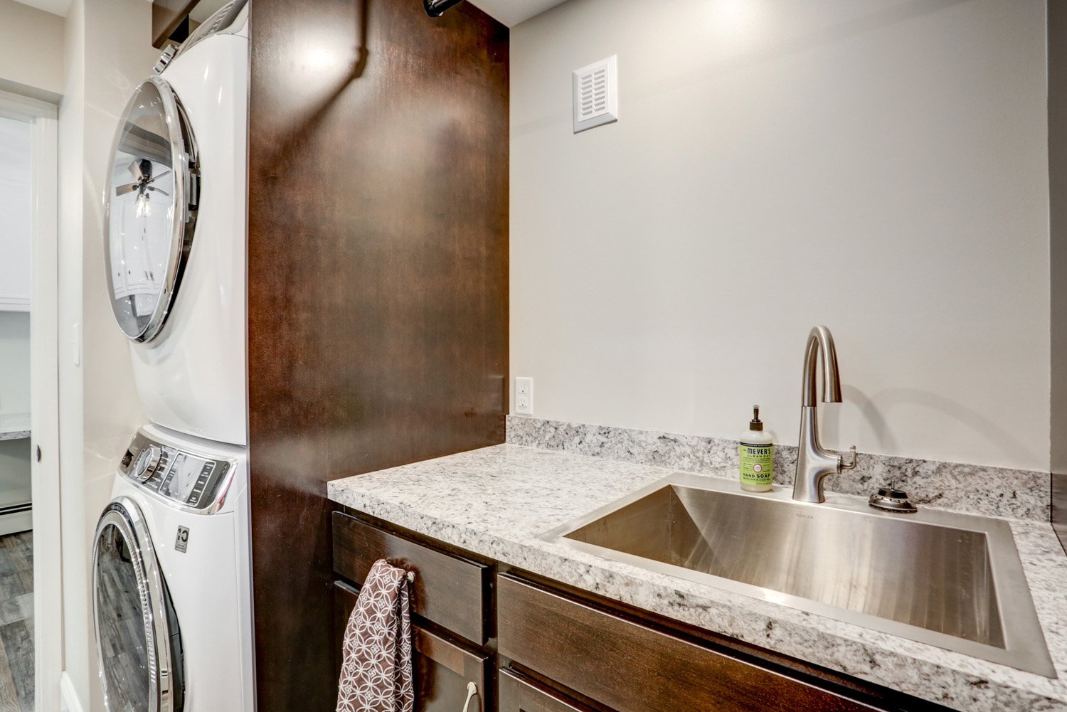 Lancaster Laundry Room Remodel with stacked washer and dryer and stainless steel sink