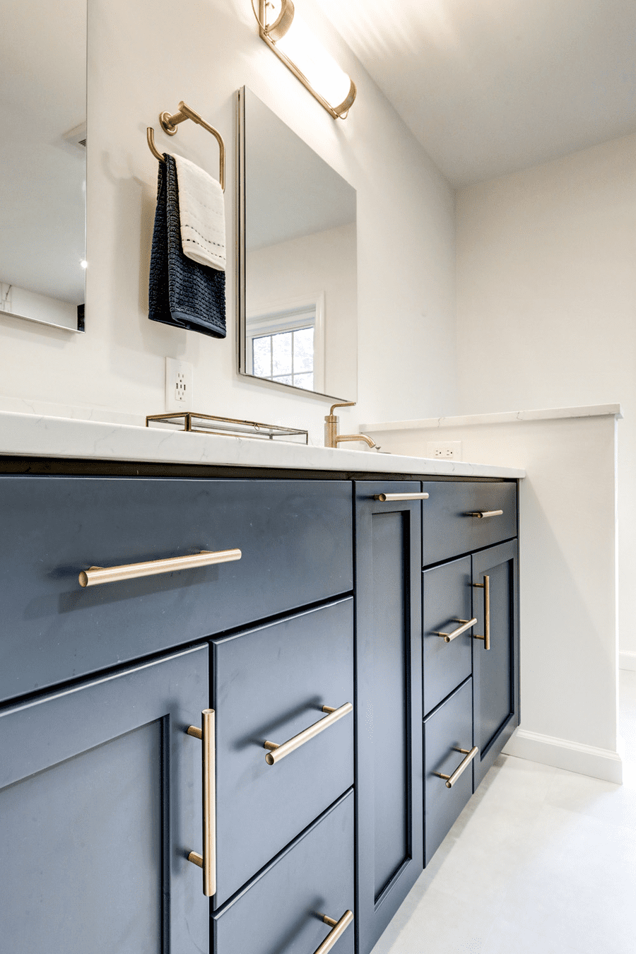 Blue vanity with gold accents and double mirrors in Hempfield Master Bathroom Remodel 