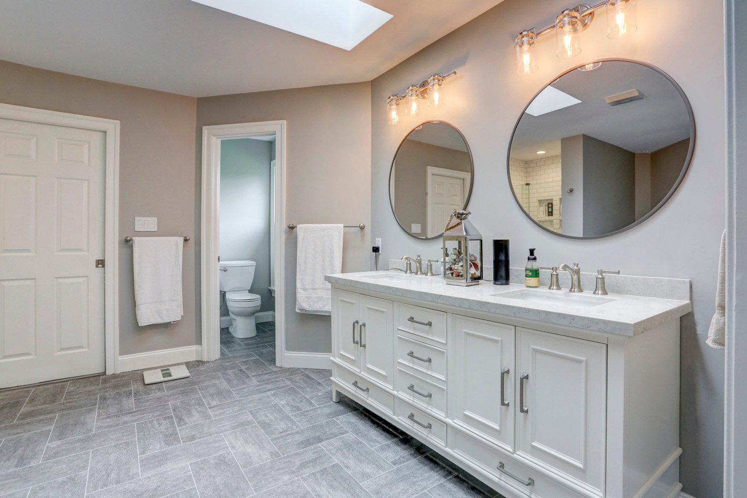 Bathroom remodel in Lancaster PA with round mirrors and double vanity
