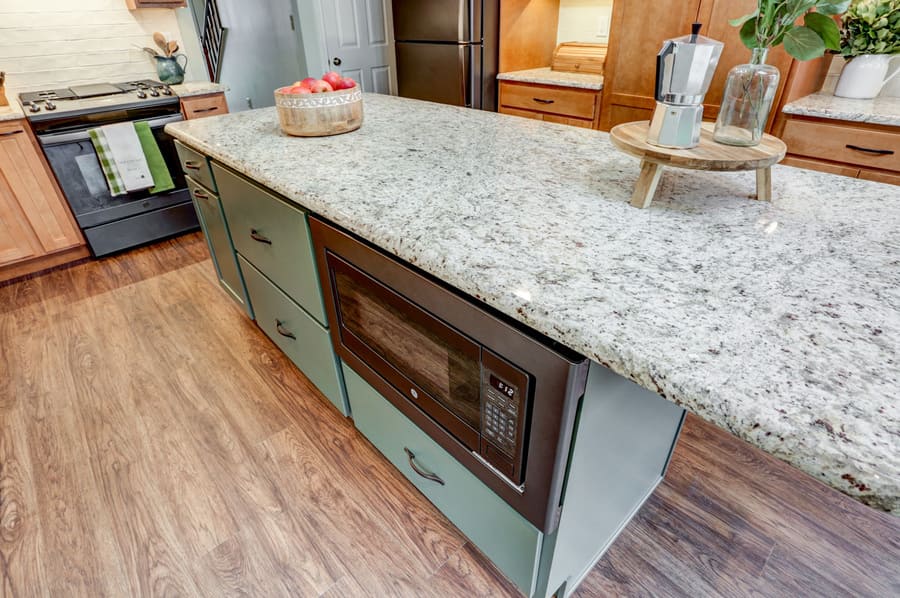 Island with granite countertop with microwave in Hempfield Kitchen Remodel