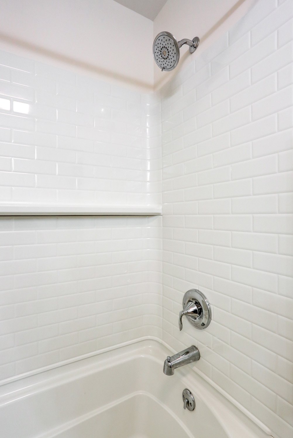 Shower with chrome accessories in Bloomingdale guest bathroom remodel