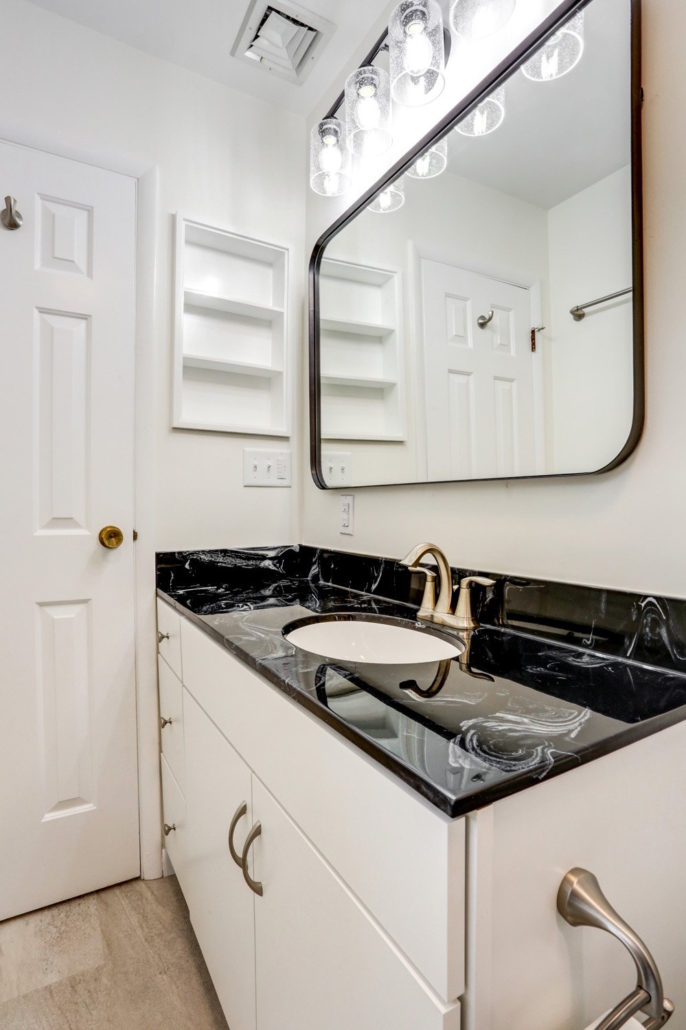 Bloomingdale Master Bathroom Remodel with white cabinets and black accents