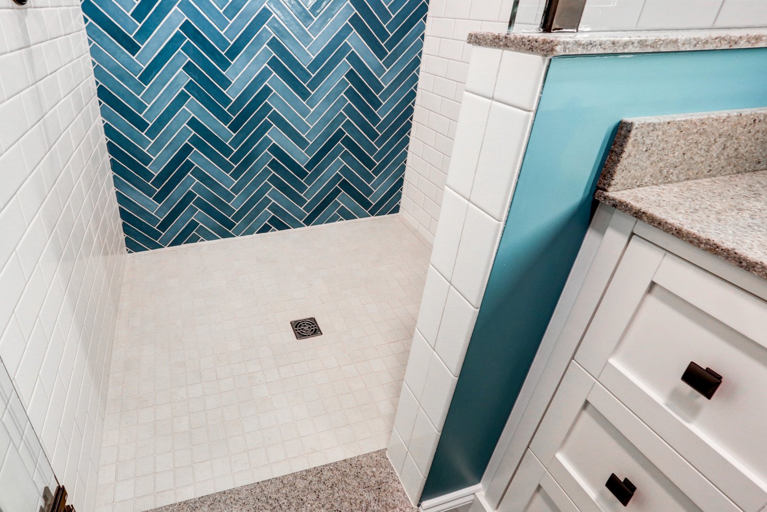 tile shower floor and white cabinets in Lititz basement bathroom addition