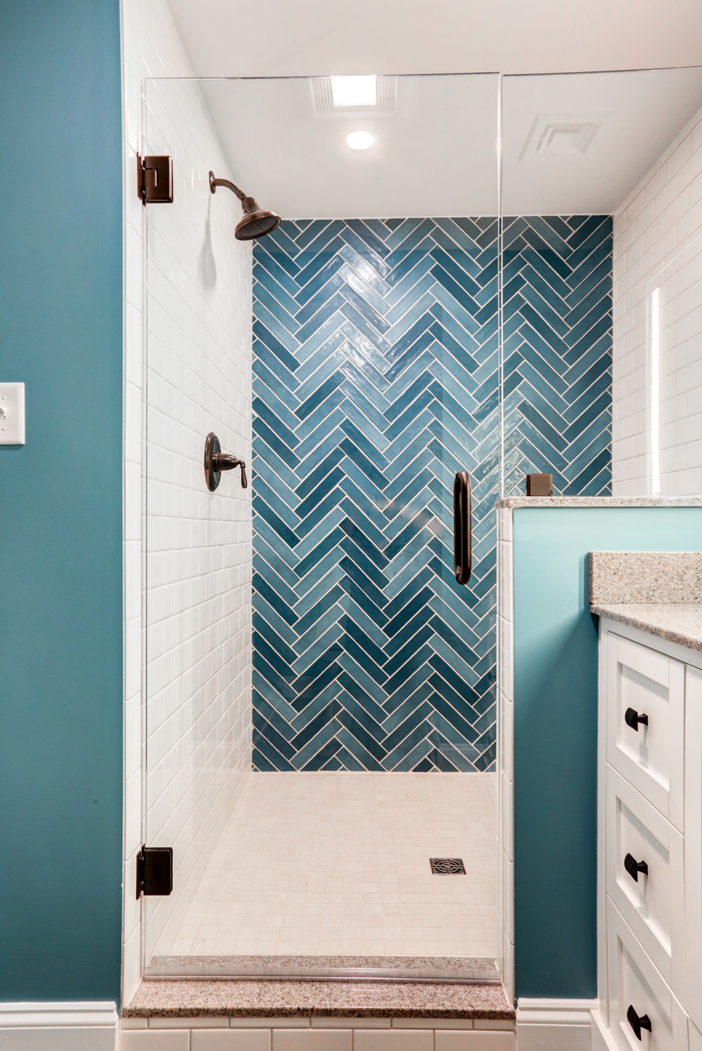 Glass shower door and blue tile in Lititz basement bathroom